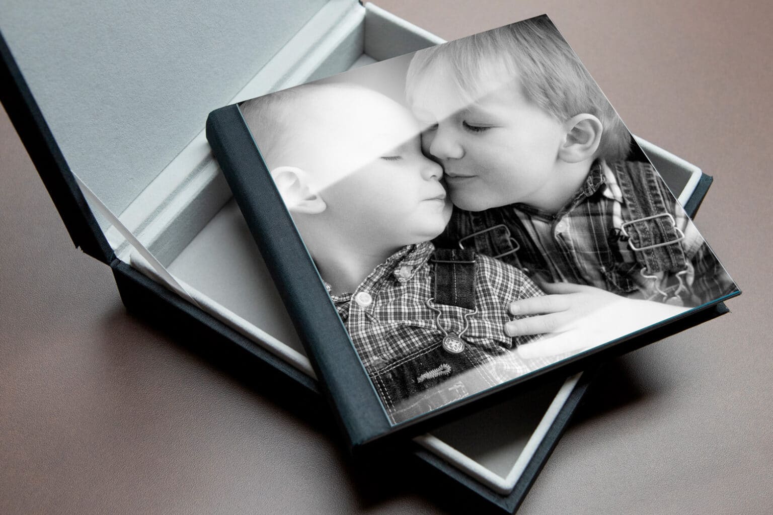 exquisite photo album on a table with picture of two little brothers hugging