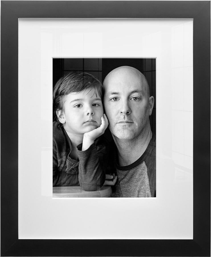 Black and white portrait of father and son elegantly framed in black and silver