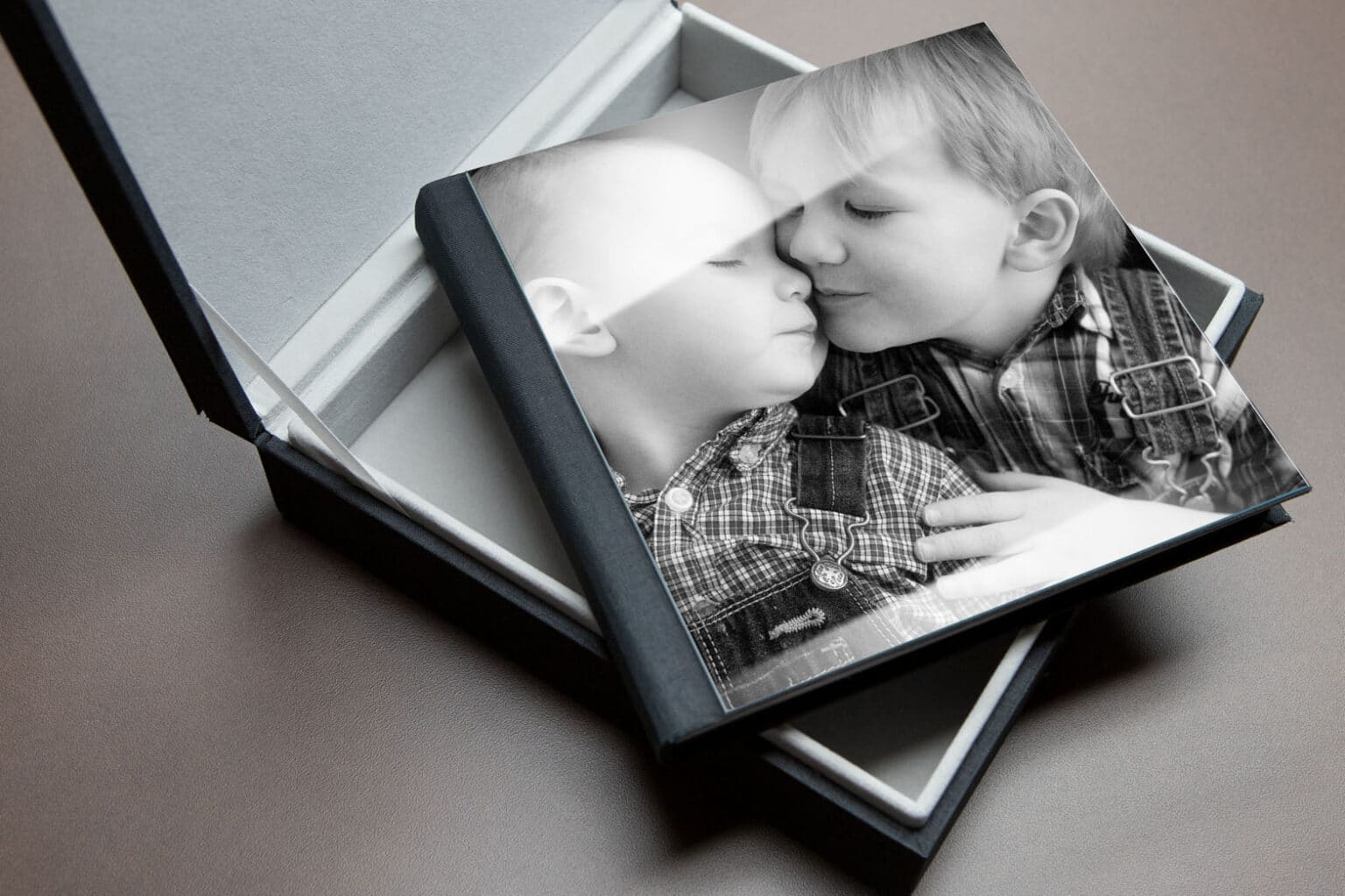 exquisite photo album on a table with picture of two little brothers hugging