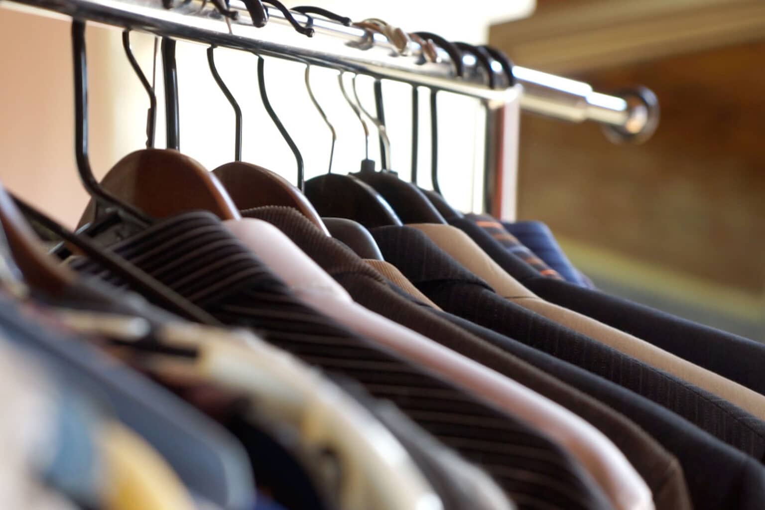 men's suit jackets hanging on a clothing rack